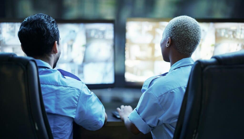 Security guard in control room, team checking screen of cctv computer together in secret office. Sa